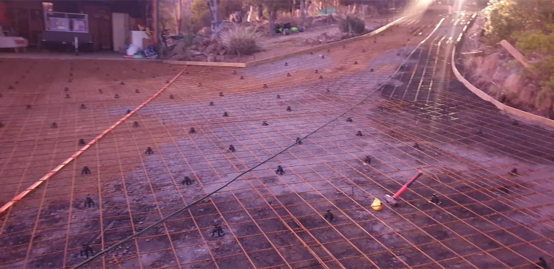 Steel mesh sheets clipped together over a graded footing base