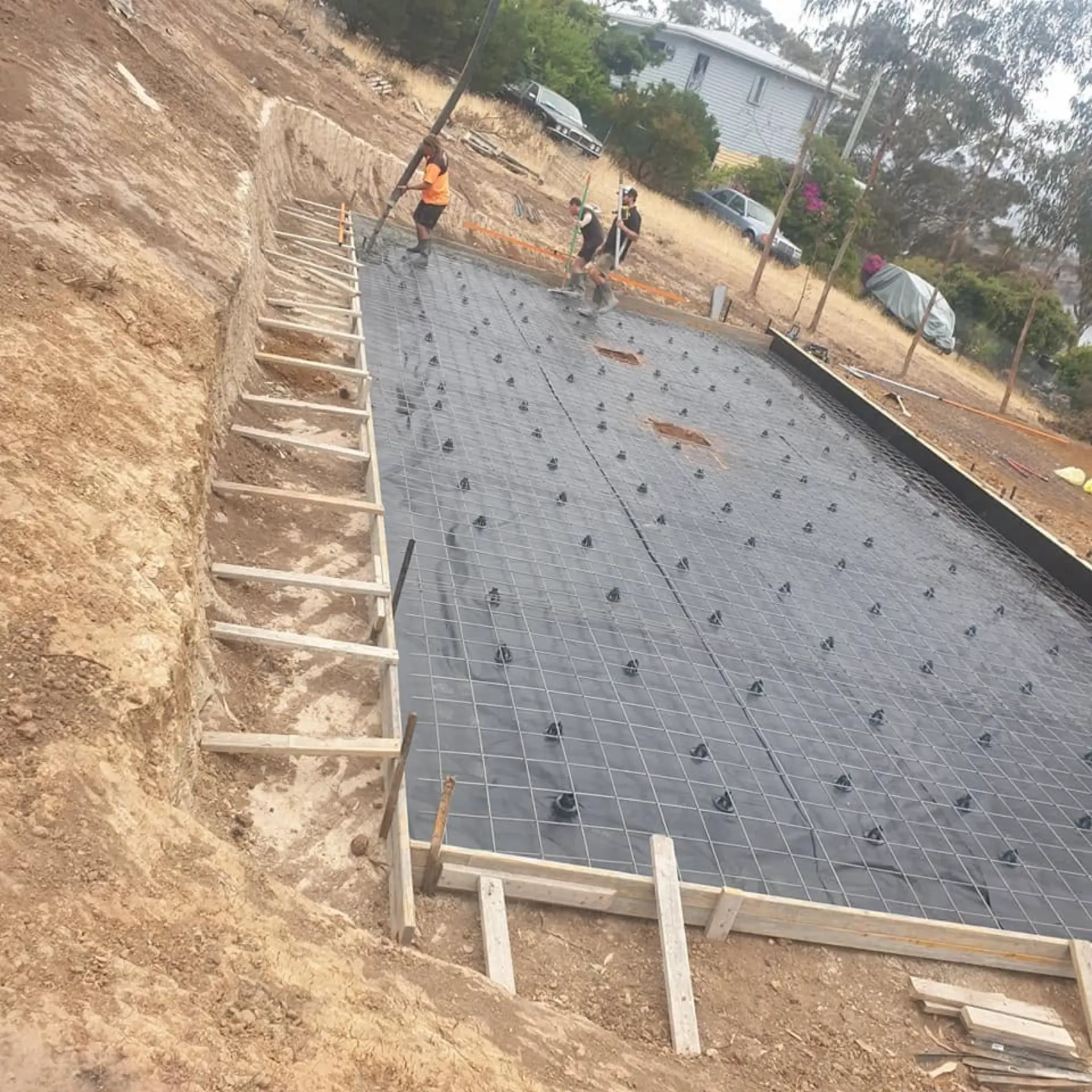 A large stepped footing and mesh grid formed up on a sloping block