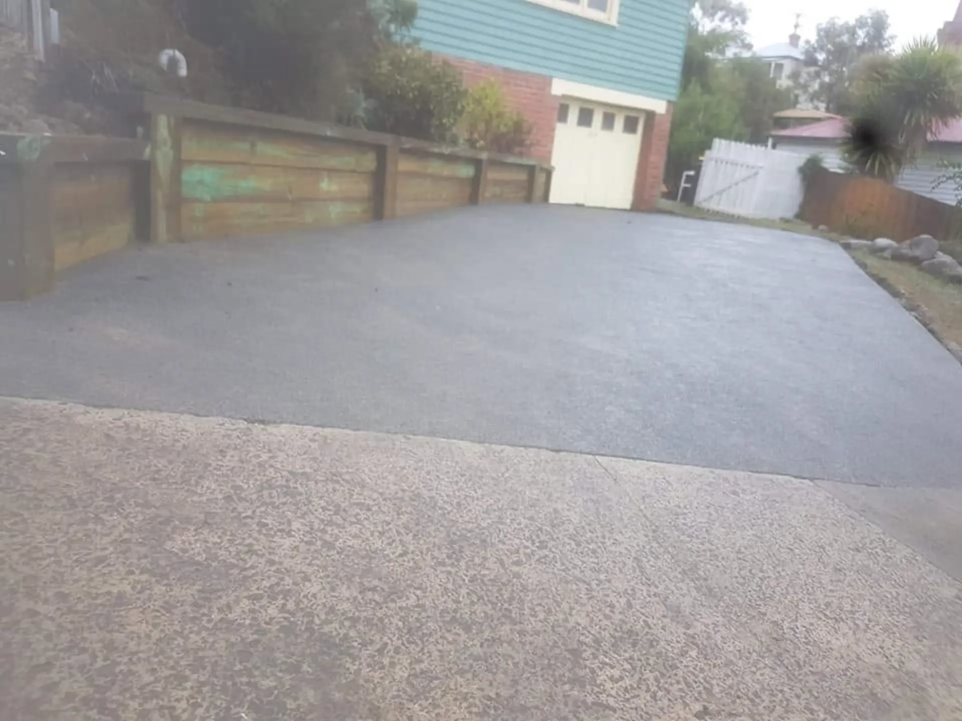 A finished concrete parking area laid behind a timber gate