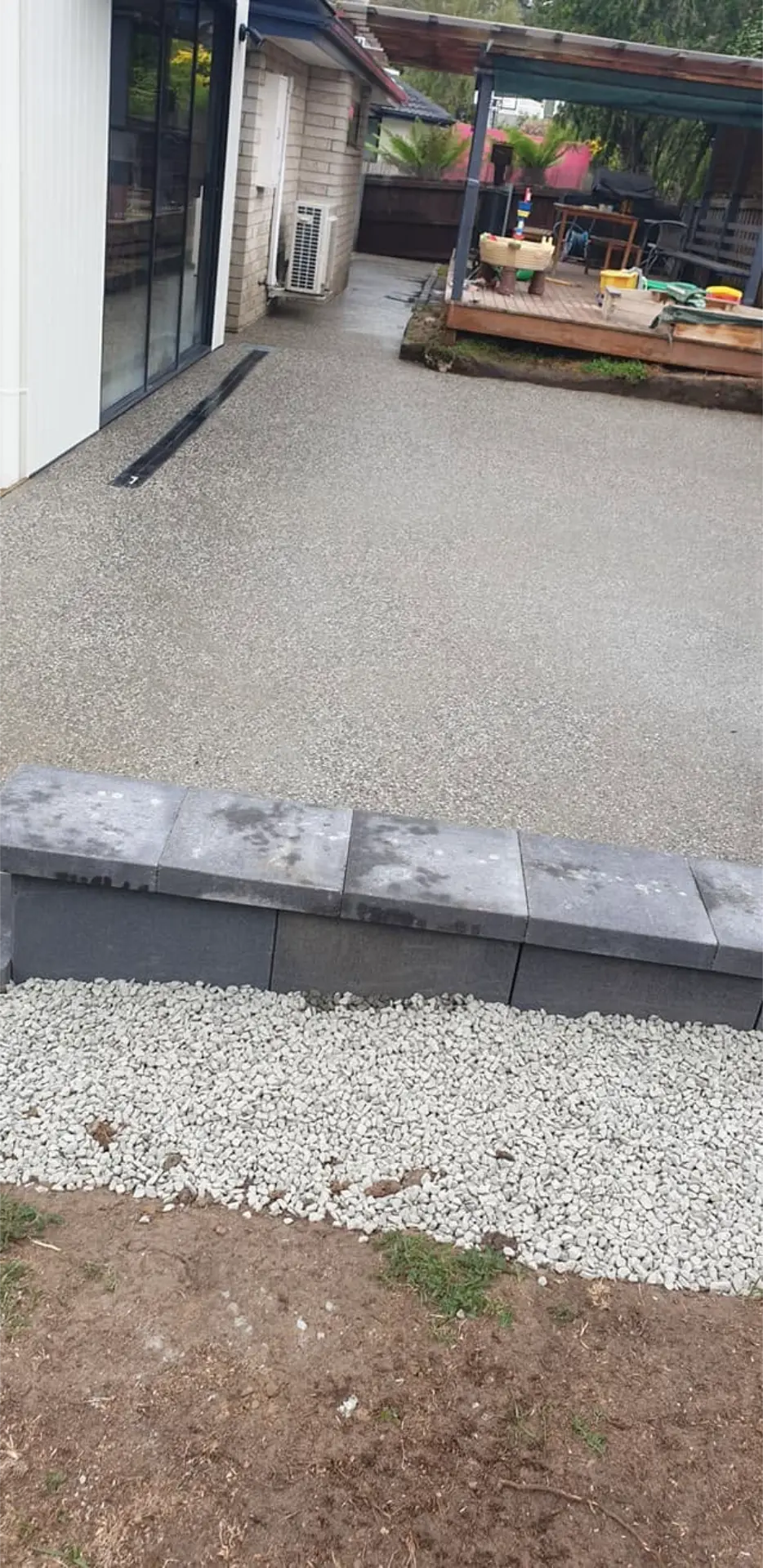 A pale exposed aggregate path finished beside a block garden edge