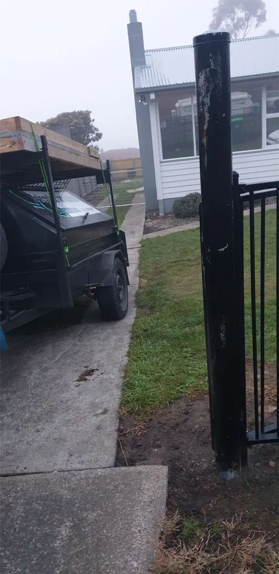 A finished concrete entry and gate area beside a suburban home