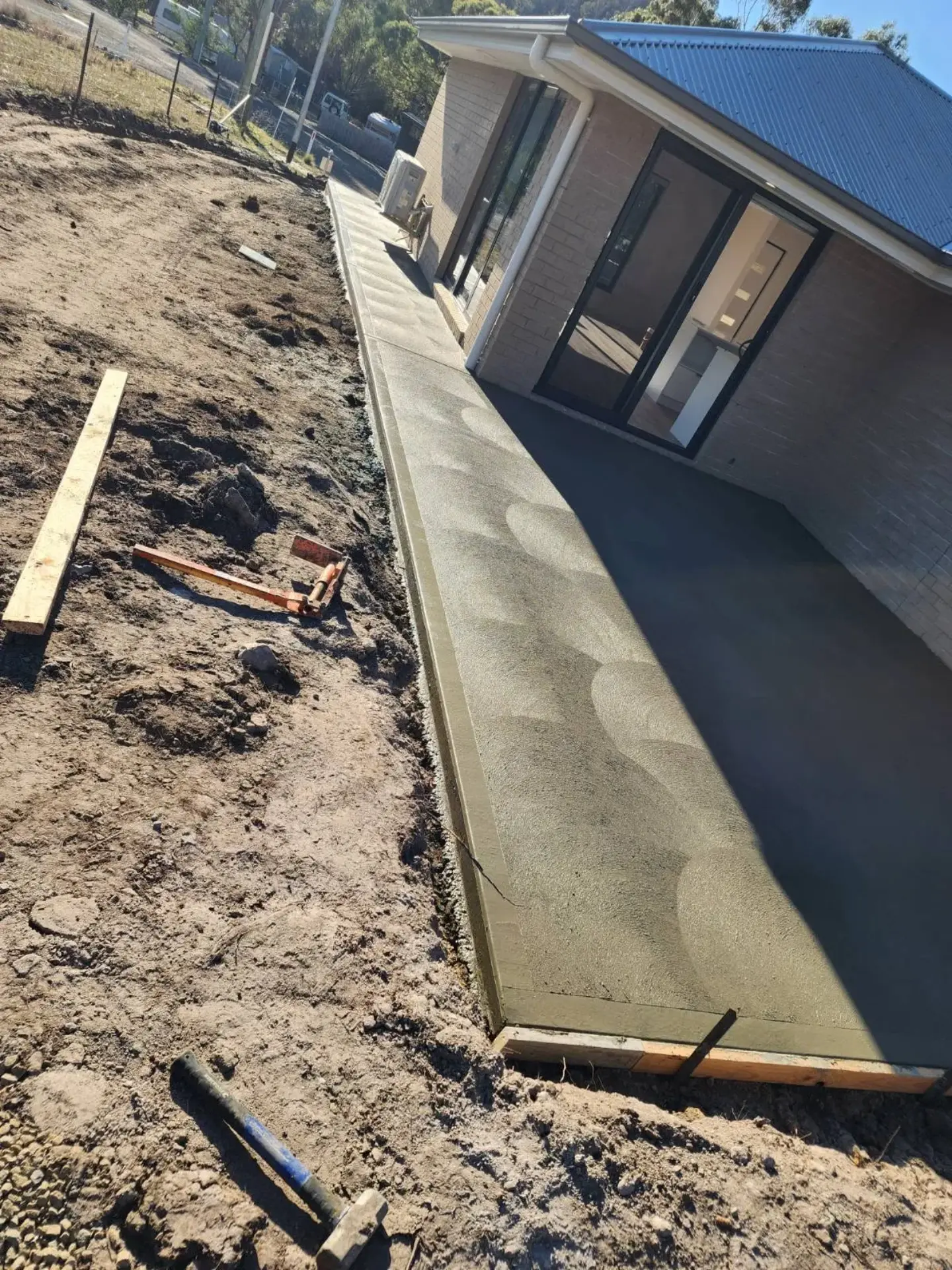 A formed concrete strip poured along the side of a new home