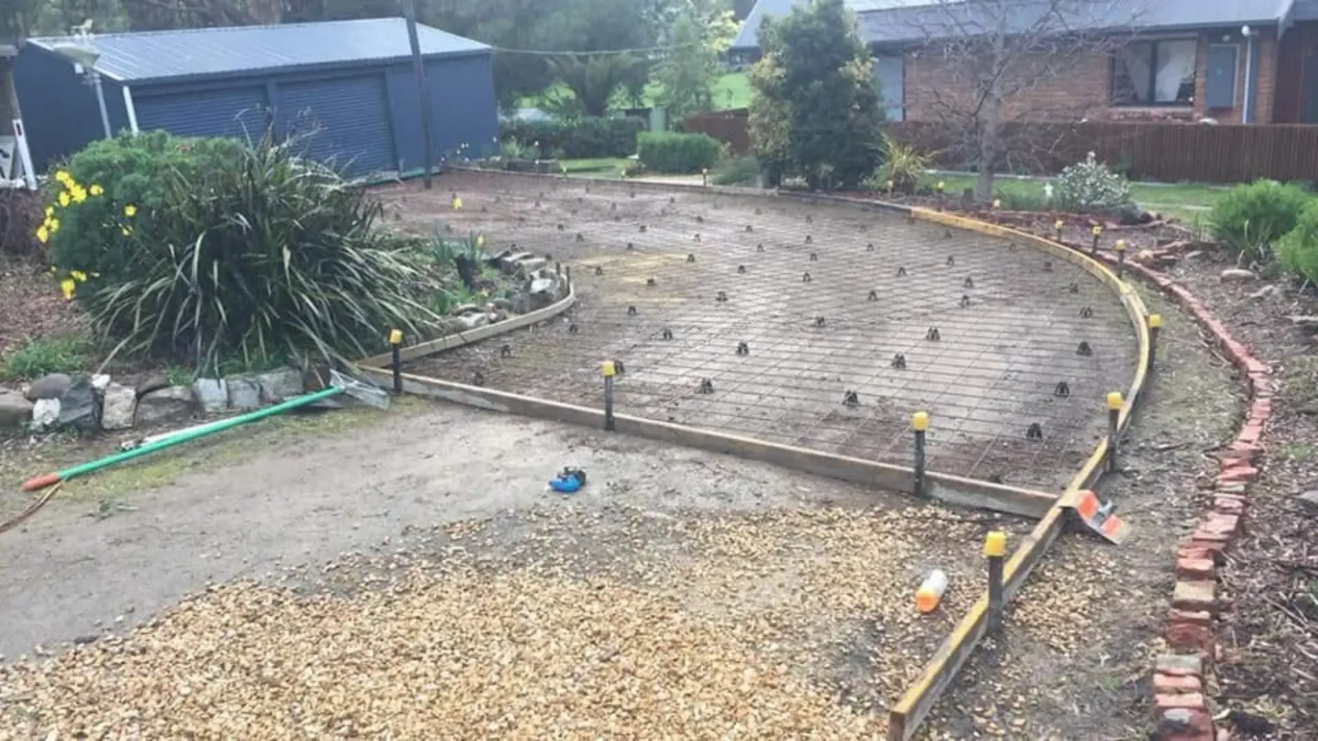 A pegged-out footing set-out with reo bars running around a garden site