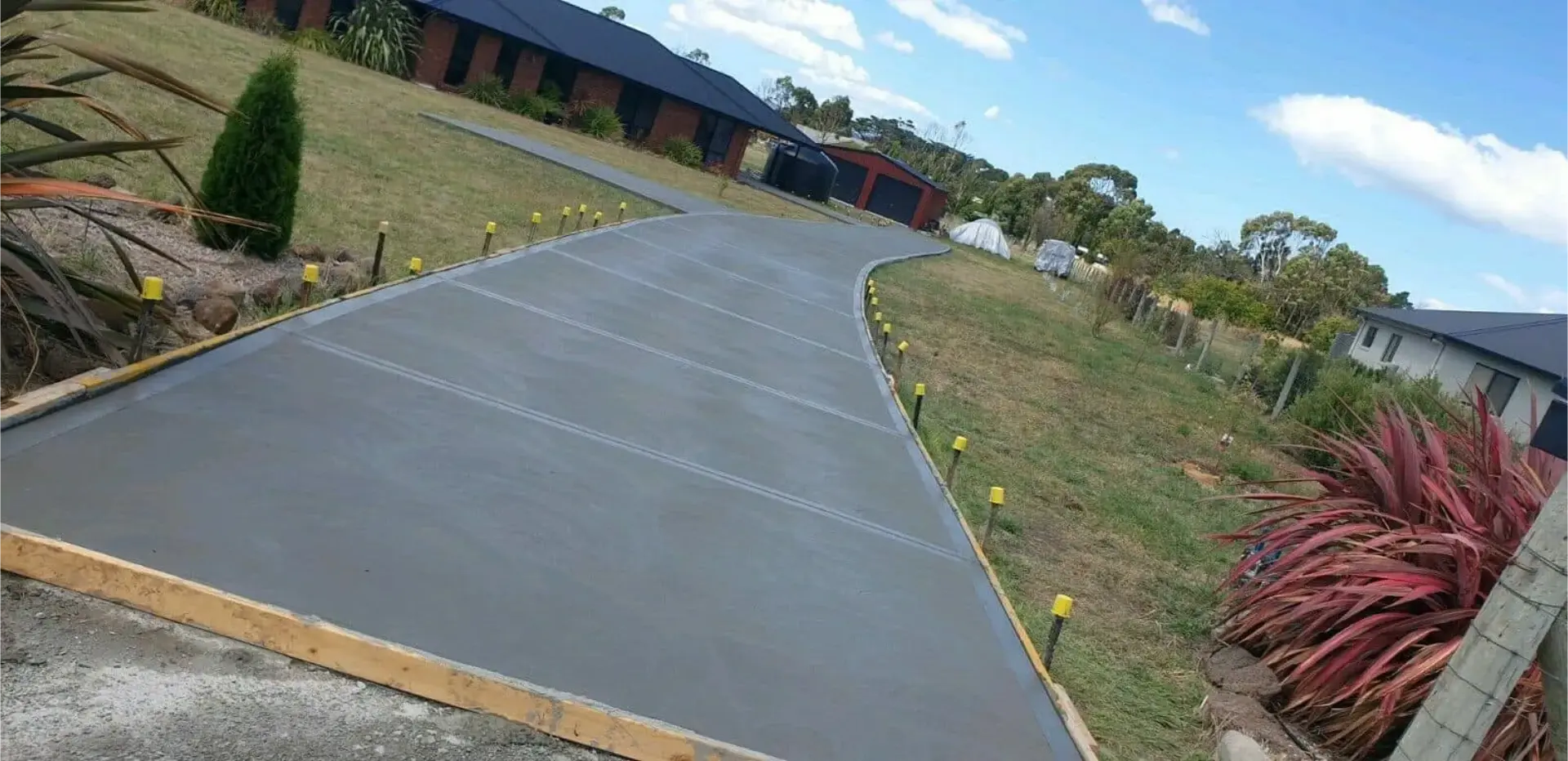 A long rural driveway strip finished between lawn and paddock fencing