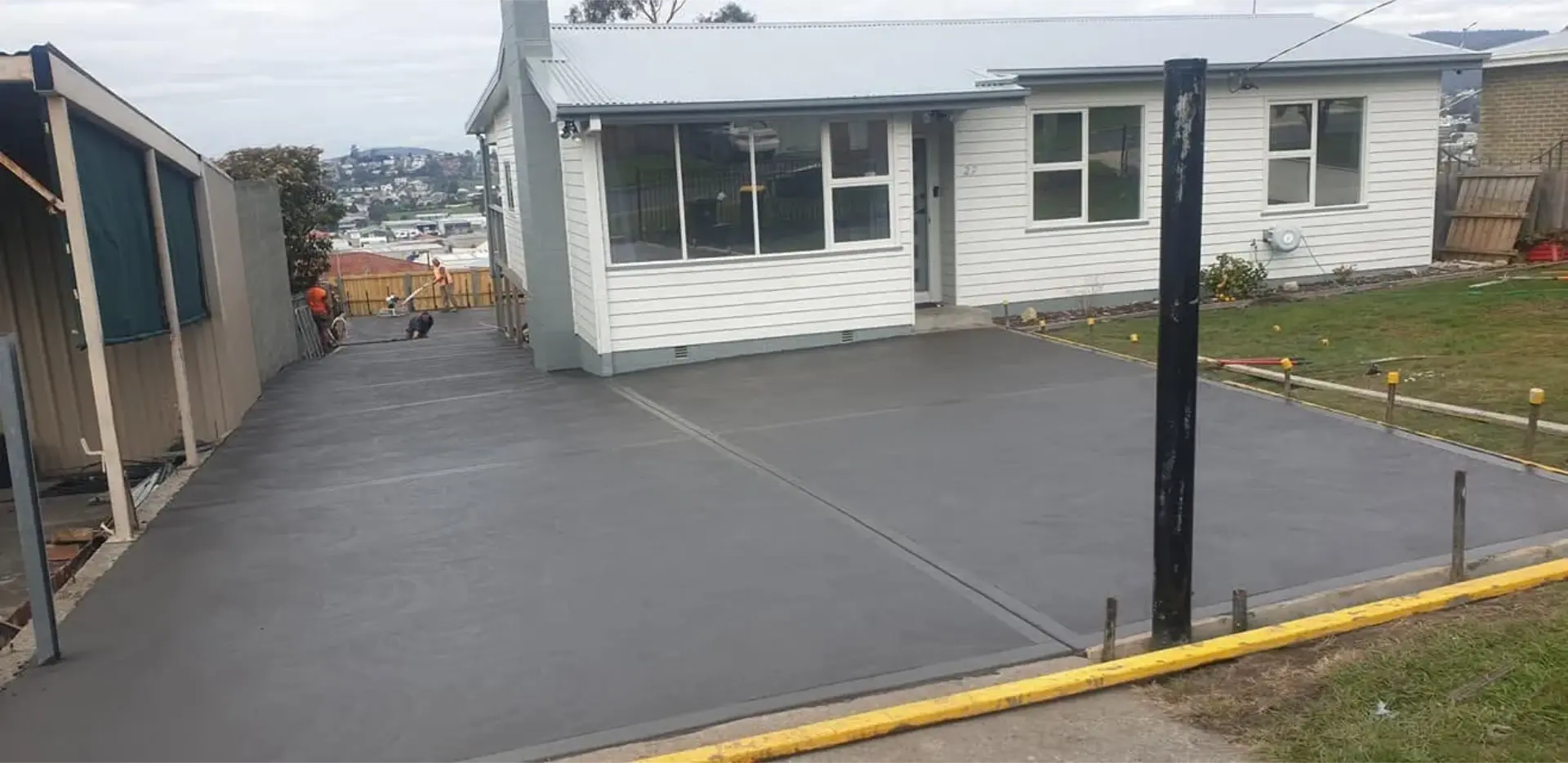 A wide finished concrete driveway curving up to a home in the Derwent Valley