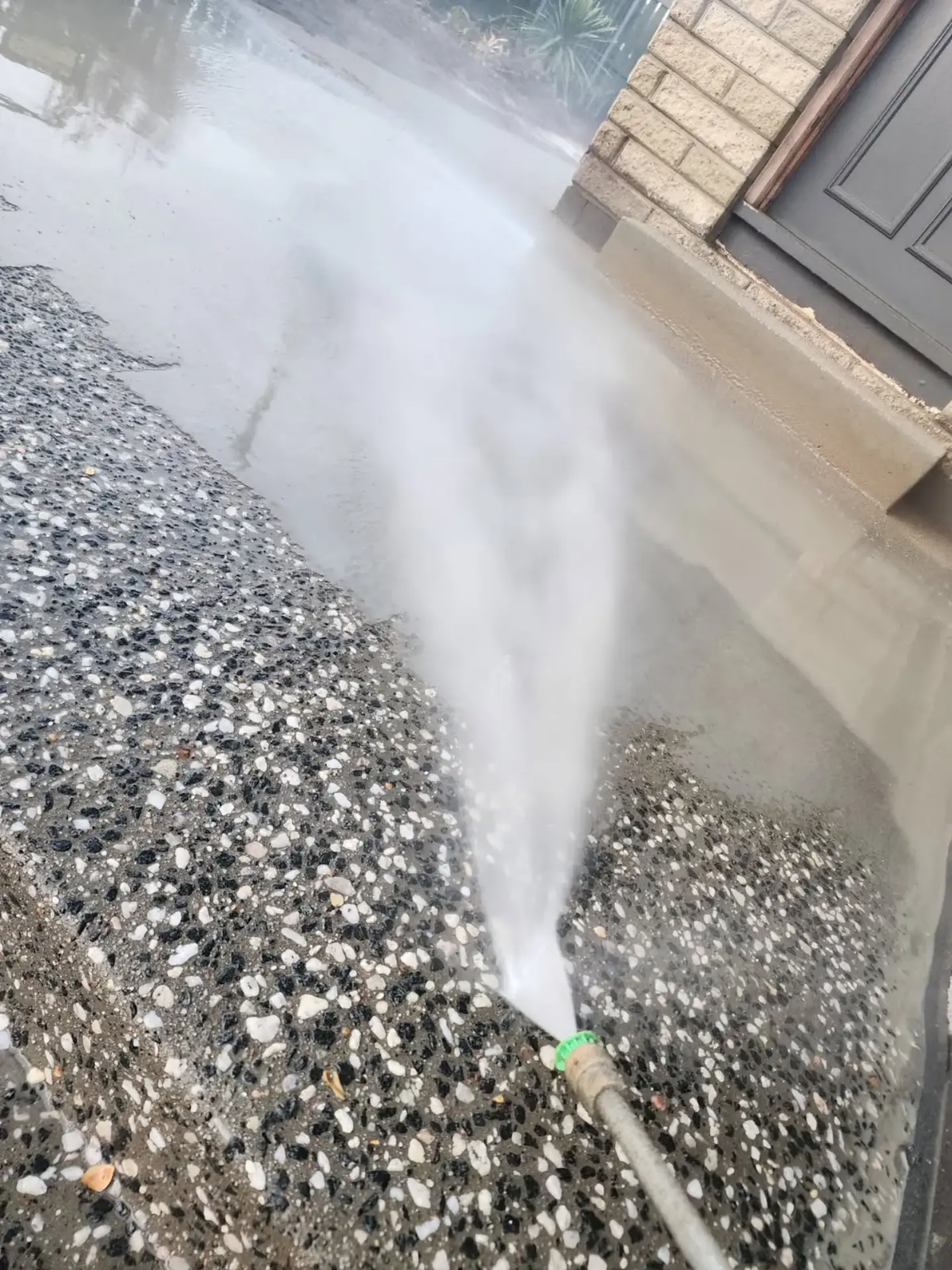 A washed exposed aggregate surface beside a rendered wall